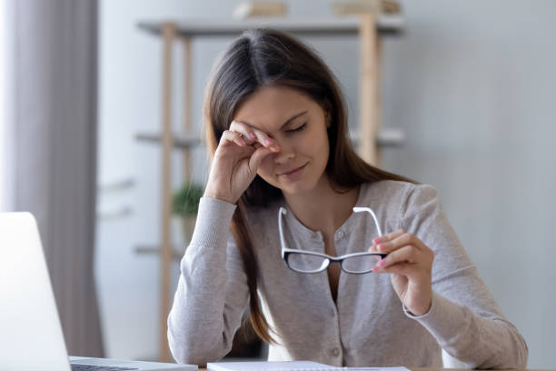 Tired woman rubbing eyes feeling fatigue from glasses computer work