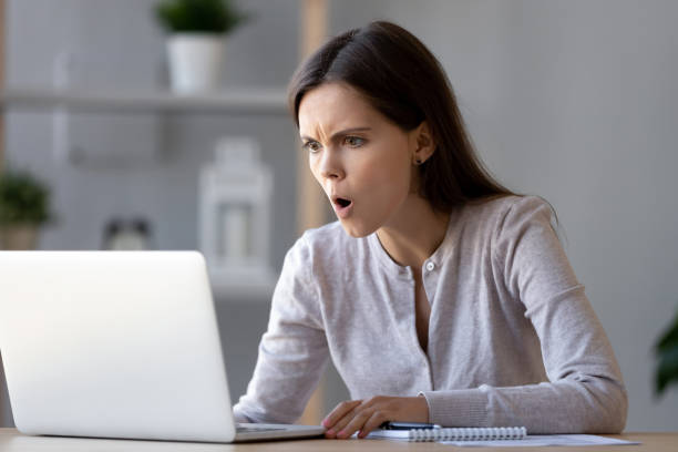 donna stressata scioccata che guarda il laptop leggere sorpresa negativa online - teenager laptop computer anger foto e immagini stock