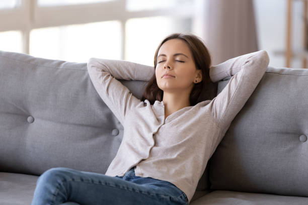 istock Young calm woman chilling relaxing leaning on comfortable sofa 1126400377
