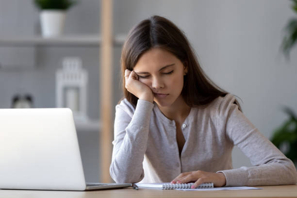 istock Bored funny woman resting on hand sleeping at workplace 1126400380