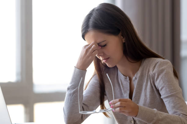 istock Overworked tired young woman student holding glasses feeling eye strain 1126400383
