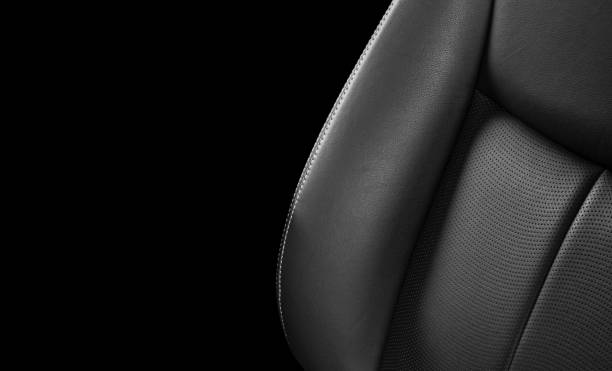 istock Black leather interior of a car. Perforated Leather comfortable seats with stitching isolated on black background. Car interior details. Car detailing. Car inside 1126400457