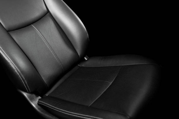 istock Black leather interior of a car. Perforated Leather comfortable seats with stitching isolated on black background. Car interior details. Car detailing. Car inside 1126400482