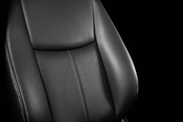 istock Black leather interior of a car. Perforated Leather comfortable seats with stitching isolated on black background. Car interior details. Car detailing. Car inside 1126400520