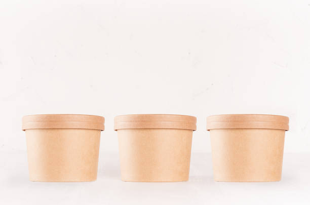 istock Set of cardboard package for different fast food for advertising, menu, banding identity - three  round containers on white wooden background. 1126401273