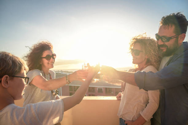 istock Cheerful Friends Toasting Drinks While Standing Against Sky During Sunset 1126402146