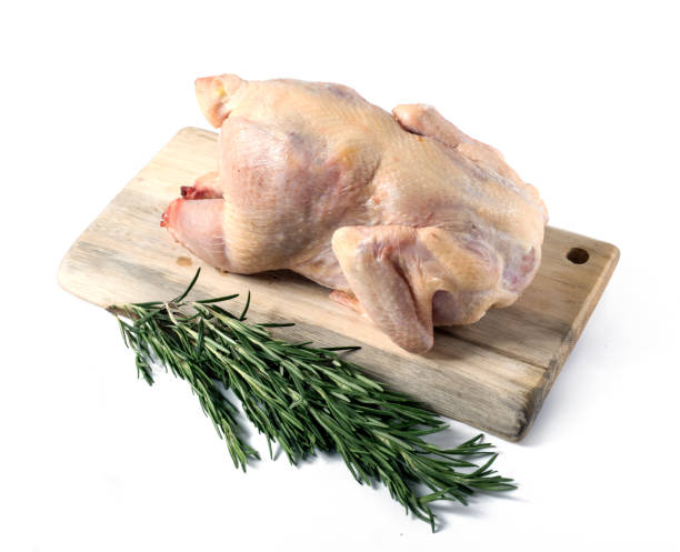 istock Cutting board with whole raw chicken on black background 1126403528