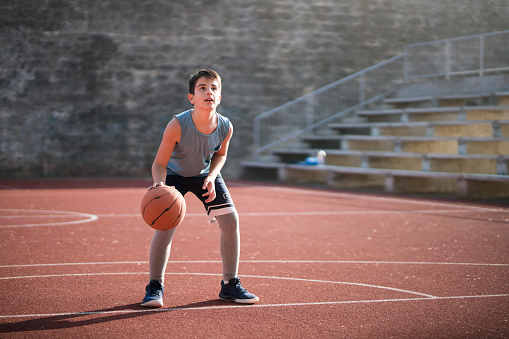 Teenage boy having a basketball training.