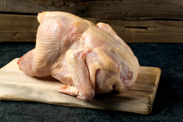 istock Cutting board with whole raw chicken 1126404022