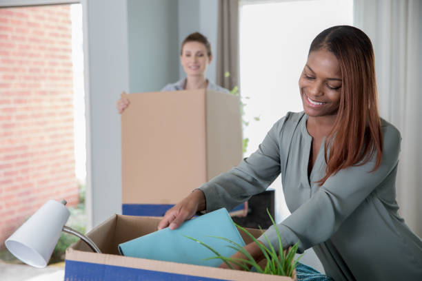 istock Diverse lesbian couple moving into new home together unpacking boxes 1126407370