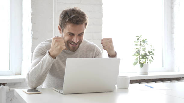 istock Casual Designer Celebrating Success, Working on Laptop 1126408055