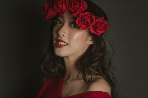 Asian woman wearing red roses crown and red sweater