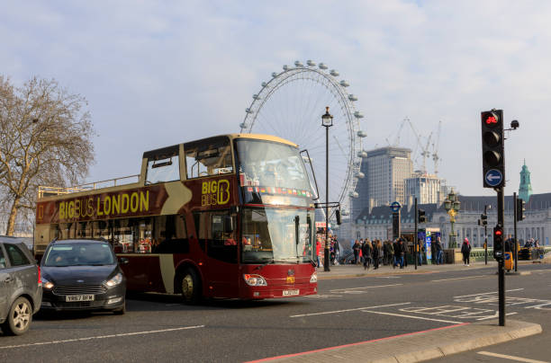 scène la ville de londres, avec le trafic traversant westminster bridge et london eye dans le fond, dans une journée ensoleillée. - london england urban scene city life bus photos et images de collection