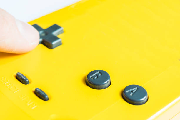 une manette jaune traditionnelle pour un jeu vidéo et un coup de main - amusement arcade arcade video game sport photos et images de collection