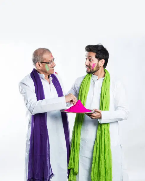 Indian father-son celebrating holi with colours. isolated over white background