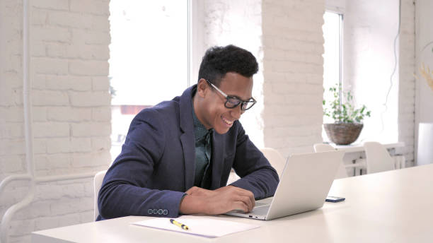 istock African Man Celebrating Success, Working on Laptop 1126411327