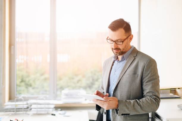 40 years old handsome businessman working on tablet - 40 44 years imagens e fotografias de stock