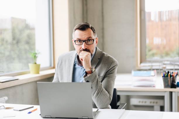 istock Middle aged handsome businessman working on laptop computer in office 1126411893