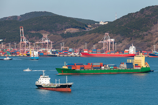 Industrial cargo ships are in Busan port area at sunny day, South Korea