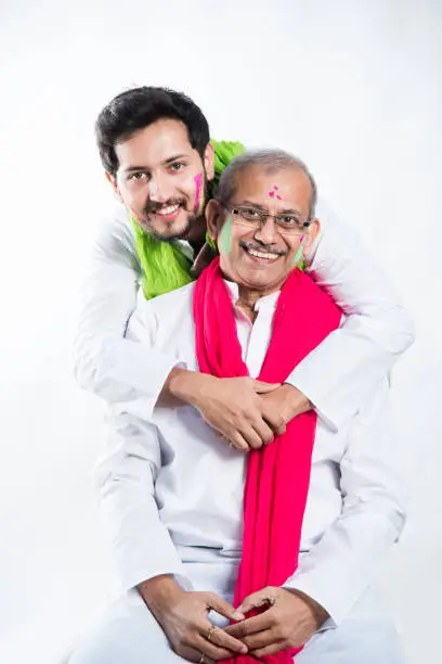 Indian father-son celebrating holi with colours. isolated over white background
