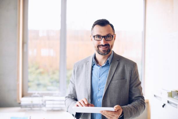 istock Smiling 40 years old handsome businessman working on laptop computer in office 1126412079