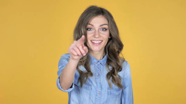 istock Young Girl Pointing at Camera Isolated on Yellow Background 1126412280