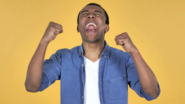 istock Young African Man Celebrating Success Isolated on Yellow Background 1126412297