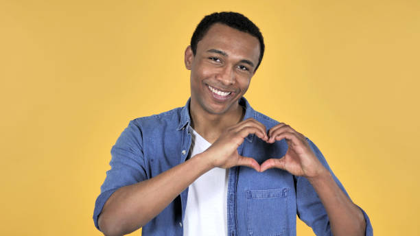 istock Handmade Heart by Young African Man Isolated on Yellow Background 1126412408