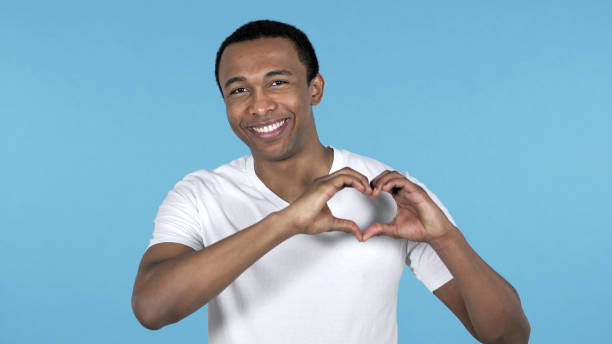 istock Handmade Heart by Young African Man Isolated on Blue Background 1126412784