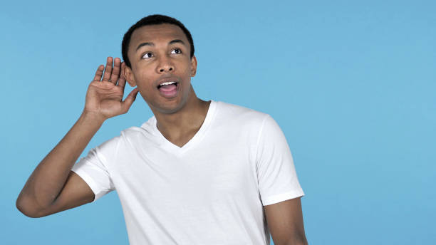 istock African Man Listening Secret Standing Isolated on Blue Background 1126412824