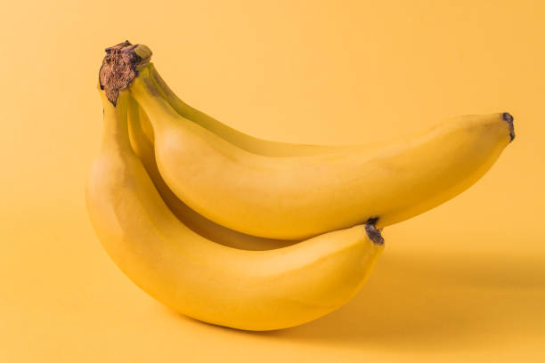 istock Minimalism style. Fruit pattern with yellow ripe banana fruit over yellow background. 1126413028