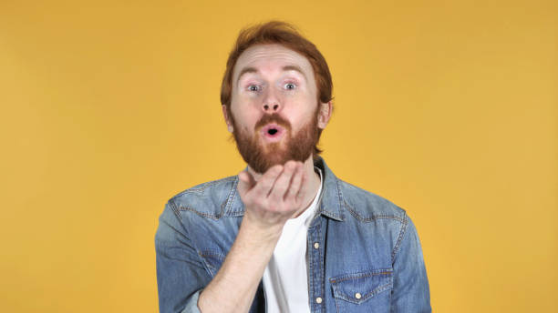 istock Flying Kiss by Redhead Man Isolated on Yellow Background 1126413584