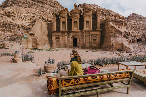 Young Caucasian woman sitting and looking at Monastery in Petra