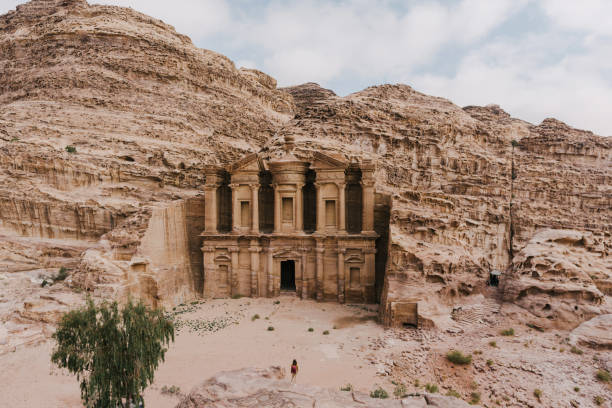 istock Woman standing on edge and looking at Monastery in Petra 1126417325