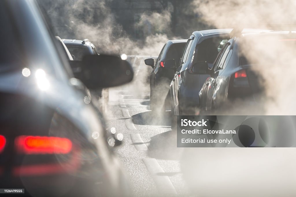 Blurred silhouettes of cars surrounded by steam from the exhaust pipes Moscow, Russia - August 08, 2017: Traffic jam. Blurred silhouettes of cars surrounded by steam from the exhaust pipes. Environmental pollution Car Stock Photo