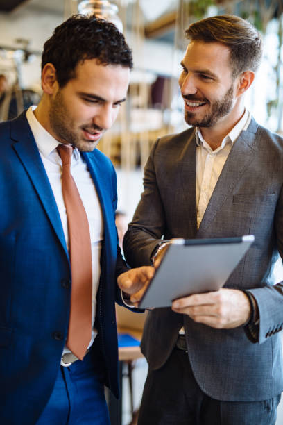 istock Two young businessmen discussing business strategy using digital tablet 1126420369