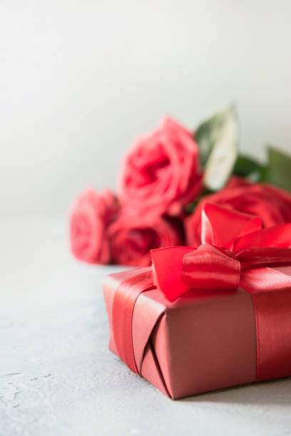 tarjeta de san valentín con caja de regalo roja, rosas bouquet en blanco. espacio para texto. - table wedding flower bow fotografías e imágenes de stock