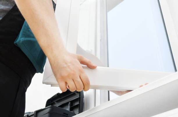 Professional handyman installing window at home. stock photo