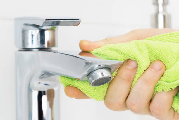 istock House cleaning. Man cleaning tap in bathroom. 1126426937