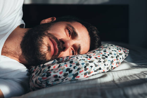 Young depressed man crying in bed Young depressed man crying in bed man crying stock pictures, royalty-free photos & images