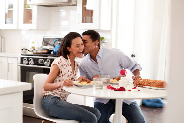 jeune couple romantique repas assis à table dans la cuisine, mise au point sélective - anniversary couple rose black photos et images de collection