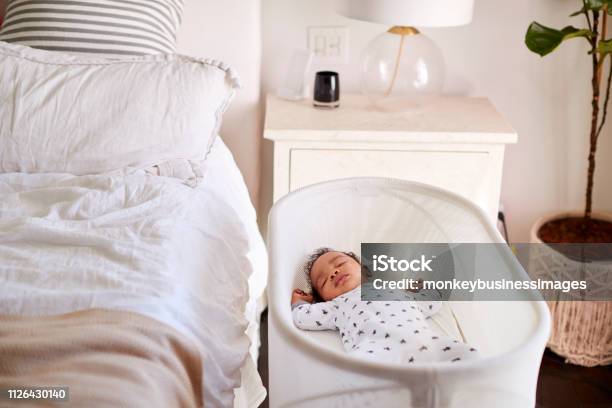Three Month Old Baby Asleep In His Cot Beside The Bed In His Motherâu20acs Bedroom Stock Photo - Download Image Now