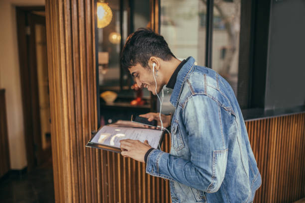 istock Guy listening to music on phone and reading menu 1126430165