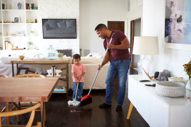 Grandfather and his three year old grandson mopping and sweeping the dining room floor, full length Grandfather and his three year old grandson mopping and sweeping the dining room floor, full length sweeping photos stock pictures, royalty-free photos & images