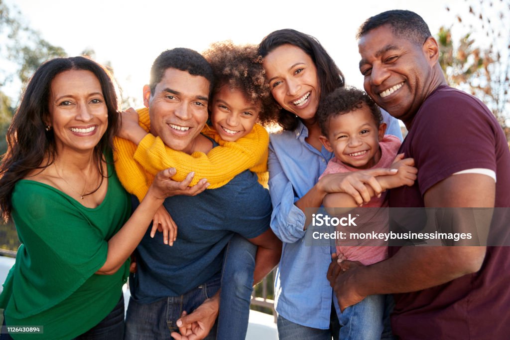 Race mixte trois génération famille jouant ensemble dans le jardin, souriant à la caméra - Photo de Groupe multi-ethnique libre de droits