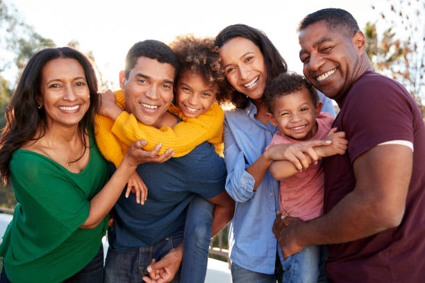 razza mista famiglia di tre generazioni che gioca insieme in giardino, sorridendo alla telecamera - multi ethnic family foto e immagini stock