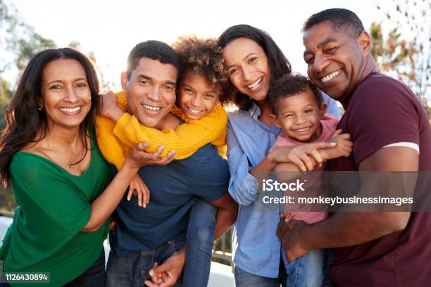 Mixed Race Three Generation Family Playing Together In The Garden Smiling To Camera Stock Photo - Download Image Now