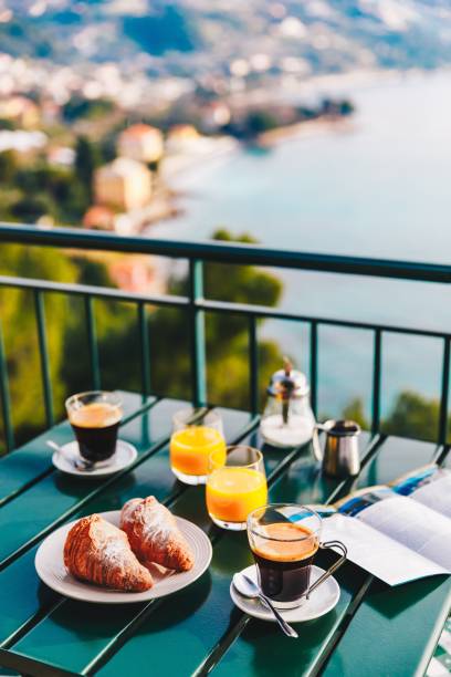 오렌지 주스와 커피, 과자, 맛 있는 조식 제공 바다 전망 발코니에서. - vacations restaurant sunlight outdoors 뉴스 사진 이미지