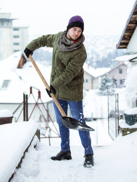 istock Young man cleans the snow 1126431946