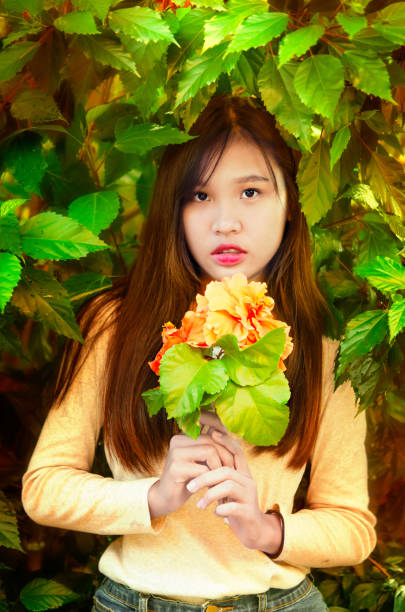 Beautiful young spring girl  with green leaves in garden